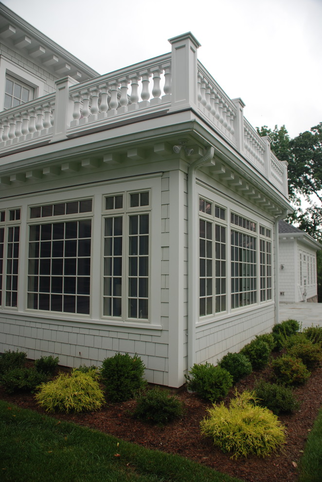 Foto della facciata di una casa grande classica a tre piani con rivestimento in legno e tetto a padiglione