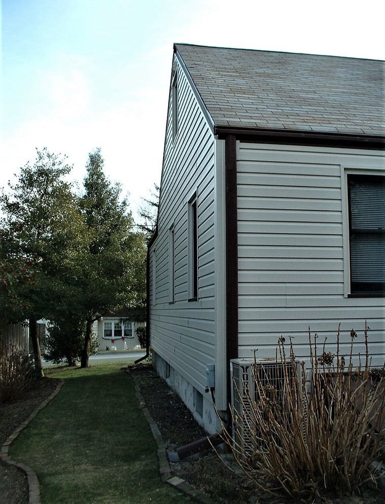 他の地域にある小さなミッドセンチュリースタイルのおしゃれな家の外観 (ビニールサイディング) の写真