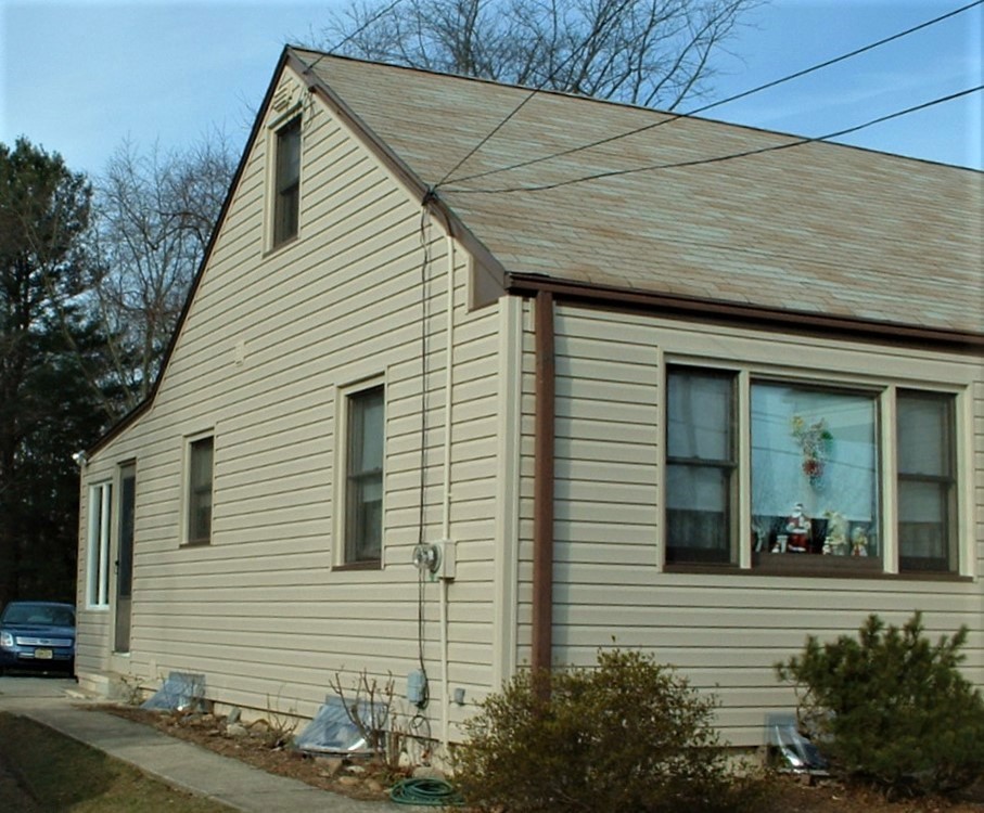 Modelo de fachada de casa beige retro pequeña de dos plantas con revestimiento de vinilo