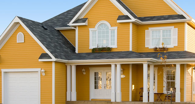 Стильный дизайн: двухэтажный, желтый дом среднего размера в современном стиле с облицовкой из винила и двускатной крышей - последний тренд