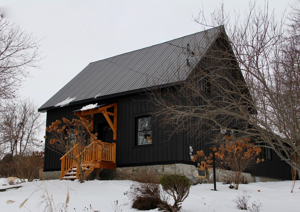Ispirazione per la facciata di una casa nera country a due piani di medie dimensioni con rivestimento in legno e copertura in metallo o lamiera