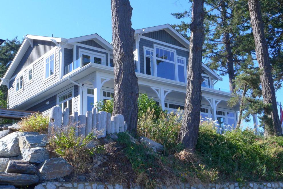 Inspiration pour une façade de maison bleue marine en bois de taille moyenne et à un étage avec un toit à deux pans et un toit en shingle.