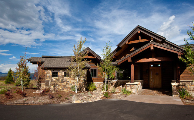 Photo of a brown rustic two floor house exterior in Denver with wood cladding.