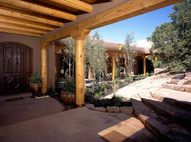 Example of a large mountain style beige one-story stucco flat roof design in Albuquerque