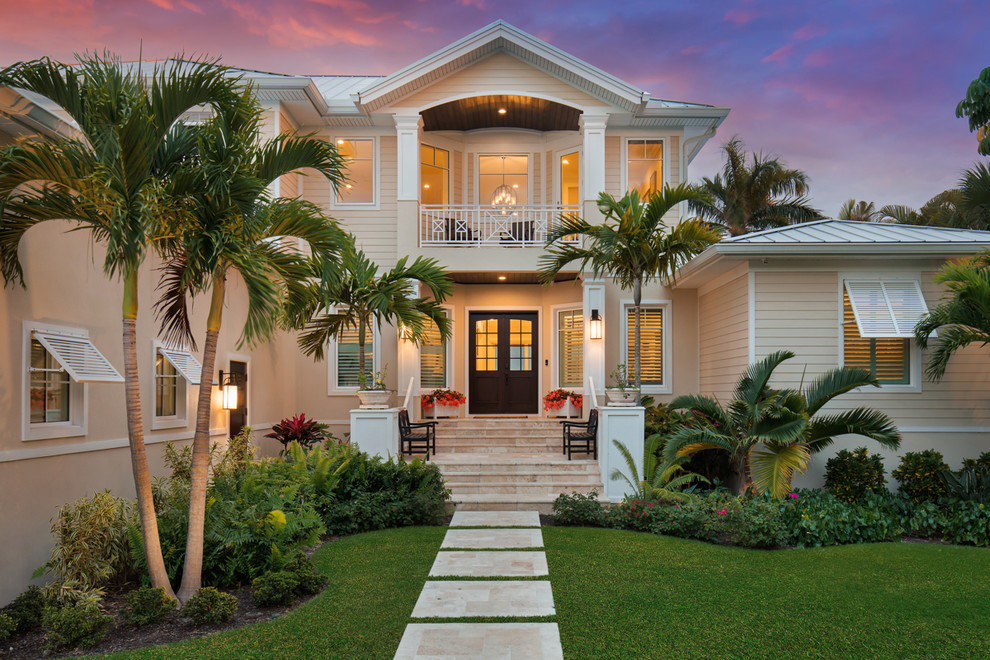 Inspiration for a large tropical beige two-story wood exterior home remodel in Tampa with a metal roof