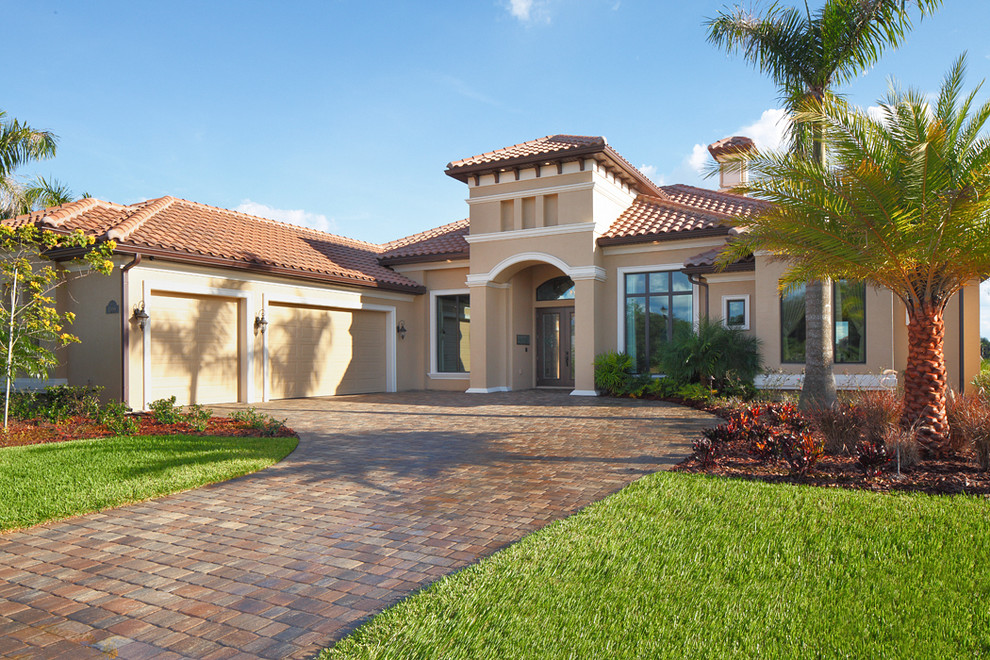 Inspiration for a large mediterranean beige one-story stucco house exterior remodel in Orlando