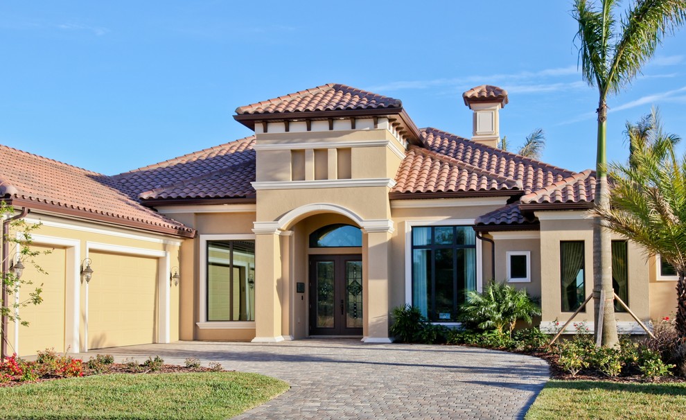 Immagine della villa grande beige mediterranea a un piano con rivestimento in stucco