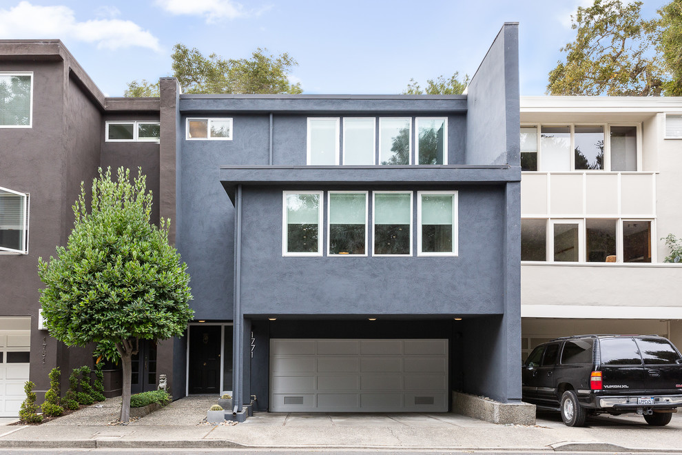 This is an example of a medium sized and blue contemporary two floor render detached house in San Francisco with a flat roof.