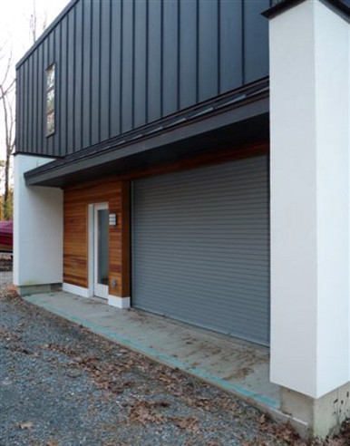 This is an example of a black contemporary two floor detached house in Boston with wood cladding and a flat roof.