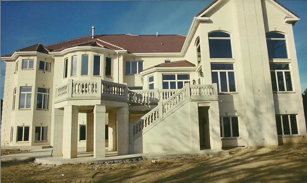 Esempio della facciata di una casa ampia mediterranea a tre piani con rivestimento in mattoni