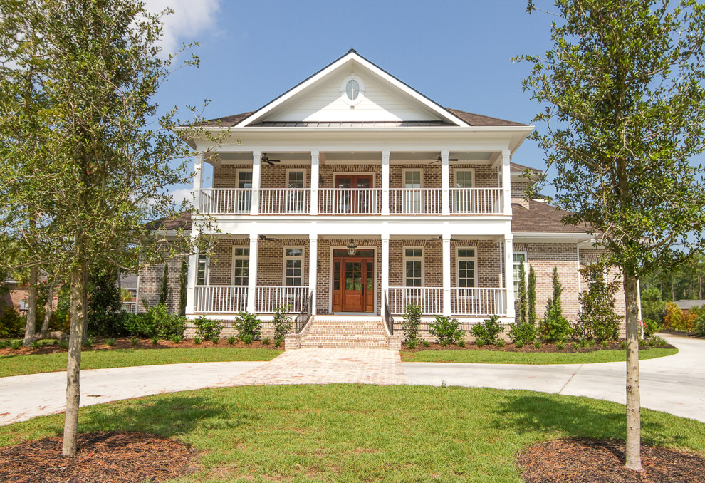 Photo of a large and white traditional two floor brick house exterior in Charleston with a hip roof.