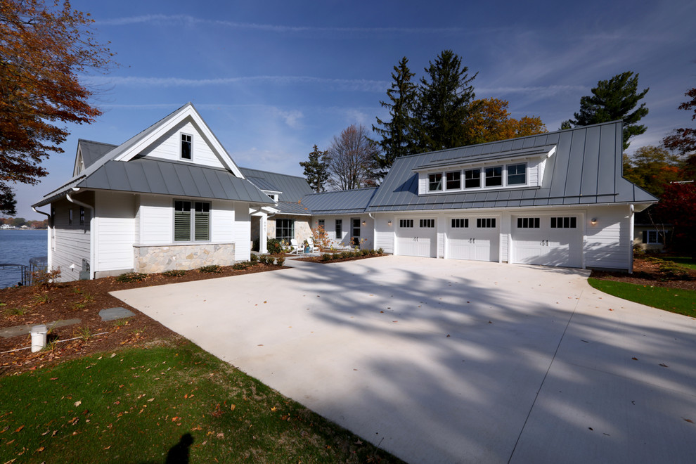 Huge coastal white two-story concrete fiberboard exterior home idea in Grand Rapids with a hip roof