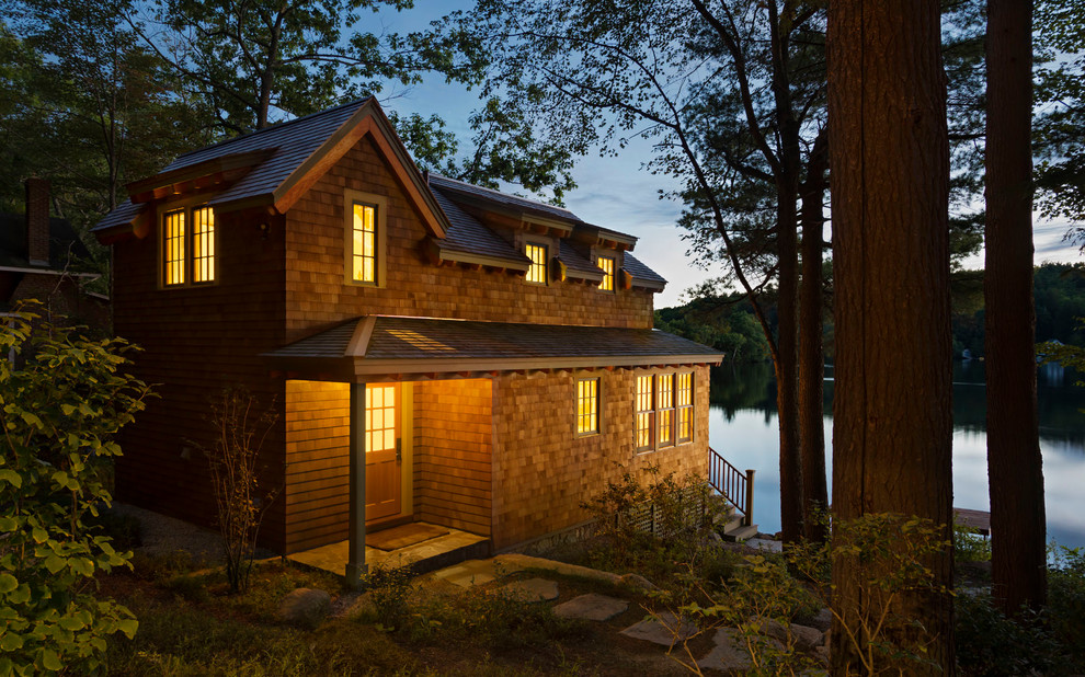 This is an example of a small and brown rustic two floor house exterior in Boston with wood cladding and a pitched roof.