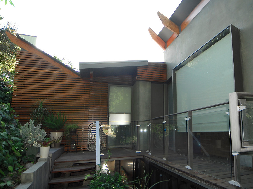 Diseño de fachada de casa gris contemporánea grande de tres plantas con revestimientos combinados