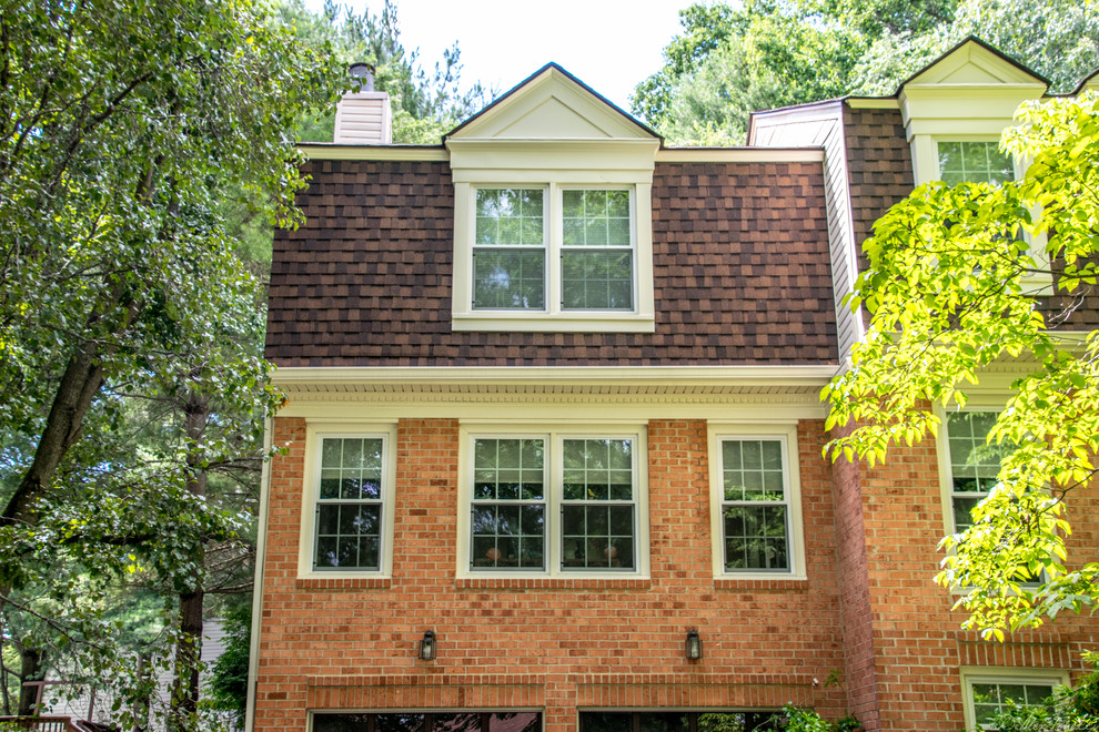 Imagen de fachada de casa roja tradicional de tamaño medio de tres plantas con revestimiento de vinilo, tejado a doble faldón y tejado de teja de madera