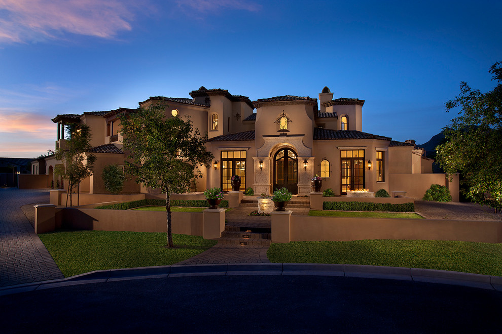 Example of a huge tuscan beige two-story stucco exterior home design in Phoenix