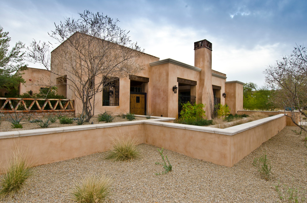 Aménagement d'une façade de maison sud-ouest américain en adobe de taille moyenne et de plain-pied avec un toit plat.
