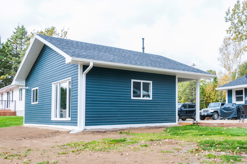 Réalisation d'une façade de maison bleue tradition de taille moyenne et de plain-pied avec un revêtement en vinyle et un toit à deux pans.