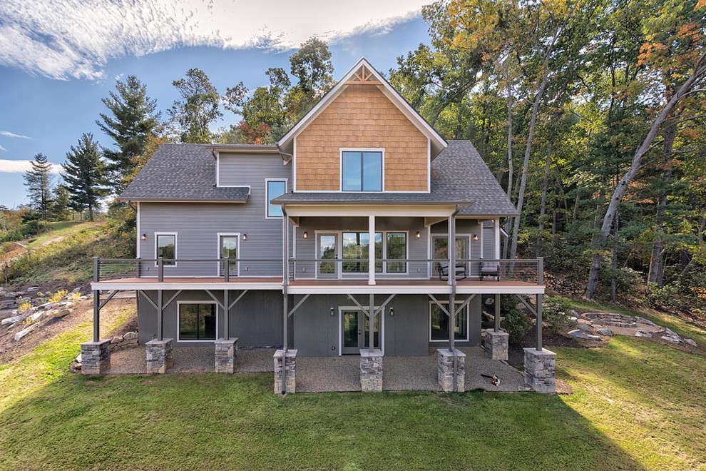 Cette photo montre une façade de maison grise montagne en bois de taille moyenne et à deux étages et plus avec un toit à deux pans.