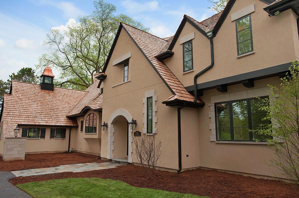Example of a large classic beige two-story stucco exterior home design in Chicago