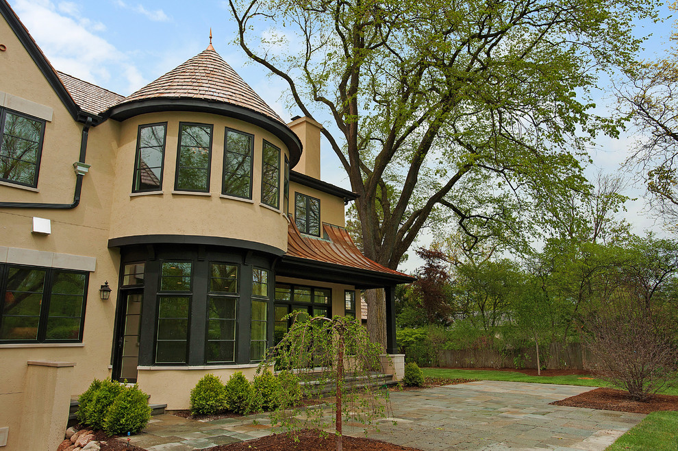 Inspiration for a large timeless beige two-story stucco exterior home remodel in Chicago