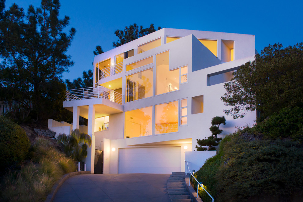 Large trendy white three-story flat roof photo in San Diego