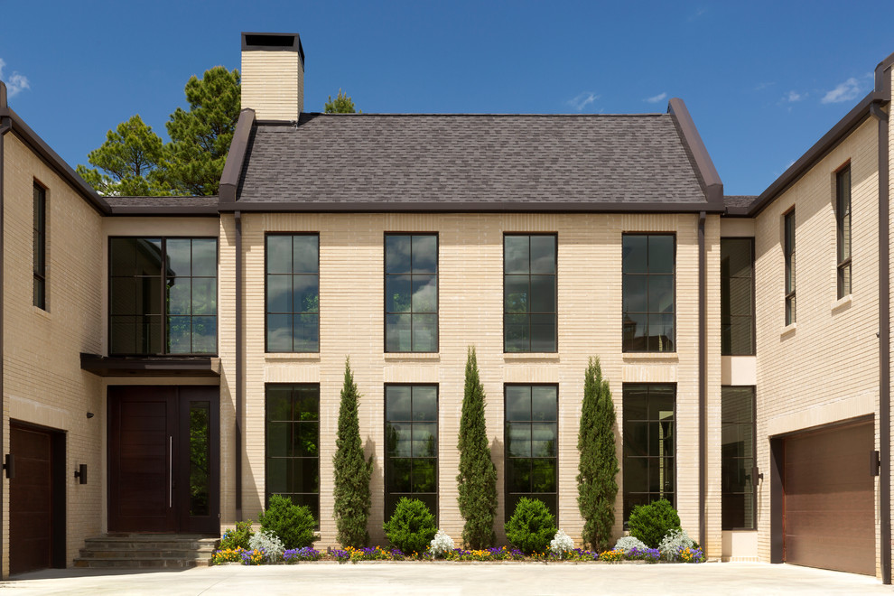 Réalisation d'une grande façade de maison beige design en brique à un étage avec un toit à deux pans.