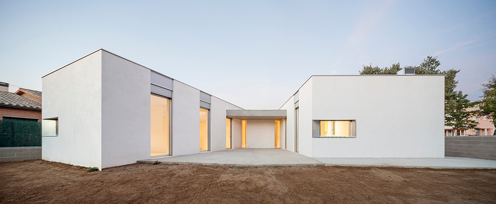 Foto de fachada blanca minimalista de tamaño medio de una planta con revestimiento de estuco y tejado plano