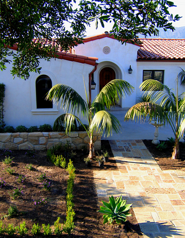 Пример оригинального дизайна: одноэтажный, белый частный загородный дом среднего размера в средиземноморском стиле с облицовкой из цементной штукатурки, полувальмовой крышей и черепичной крышей