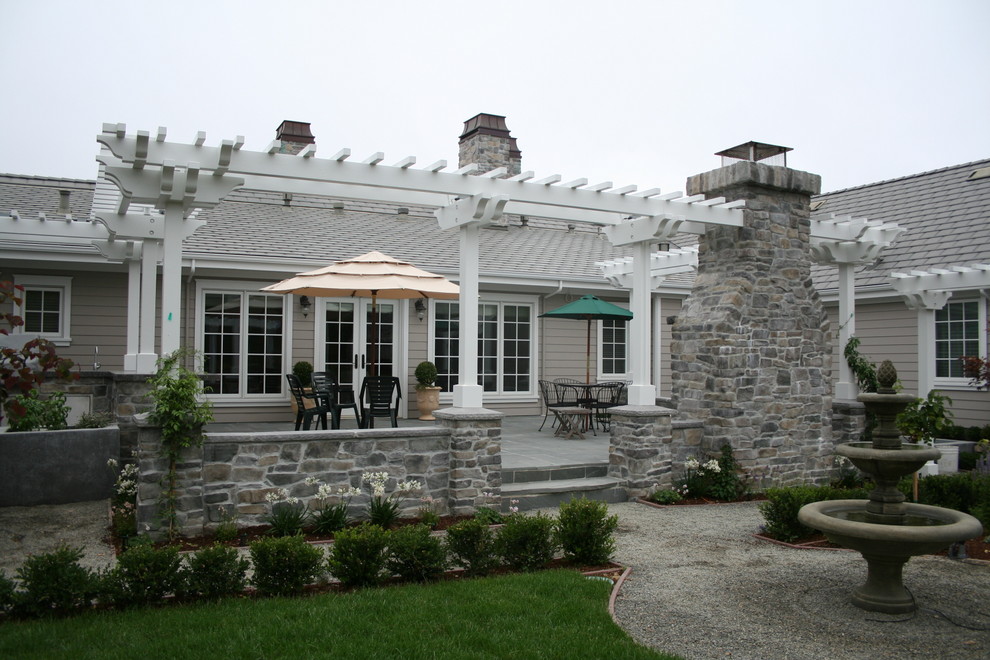 На фото: одноэтажный, серый дом в классическом стиле с облицовкой из камня с