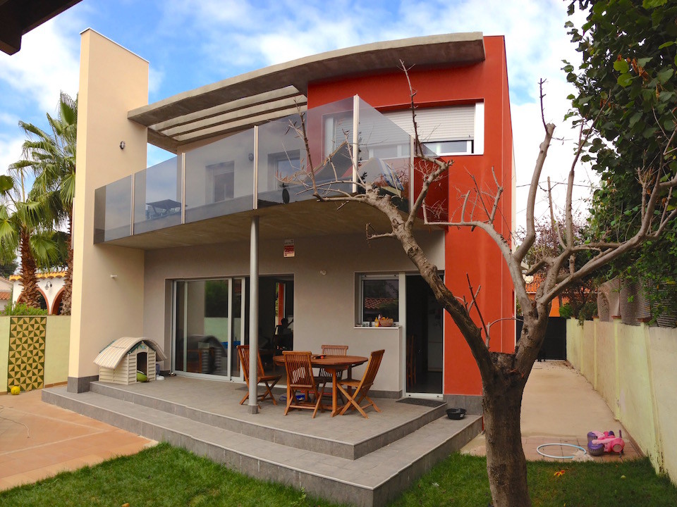 Ispirazione per la facciata di una casa rossa eclettica a due piani di medie dimensioni con rivestimento in cemento e tetto piano