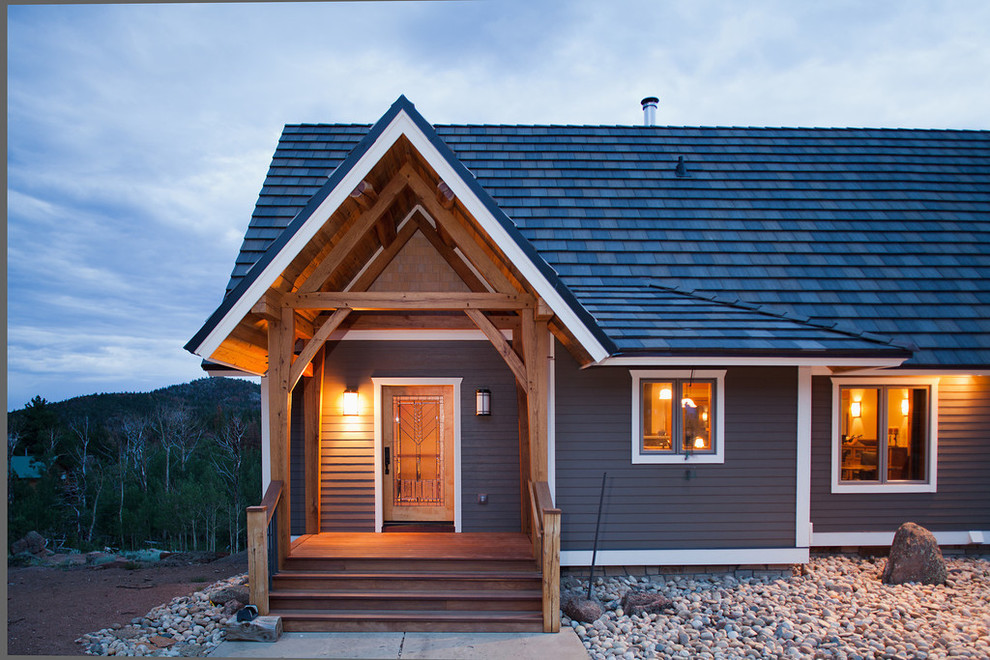 Cette image montre une façade de maison grise chalet en bois de taille moyenne et de plain-pied avec un toit à deux pans et un toit en shingle.