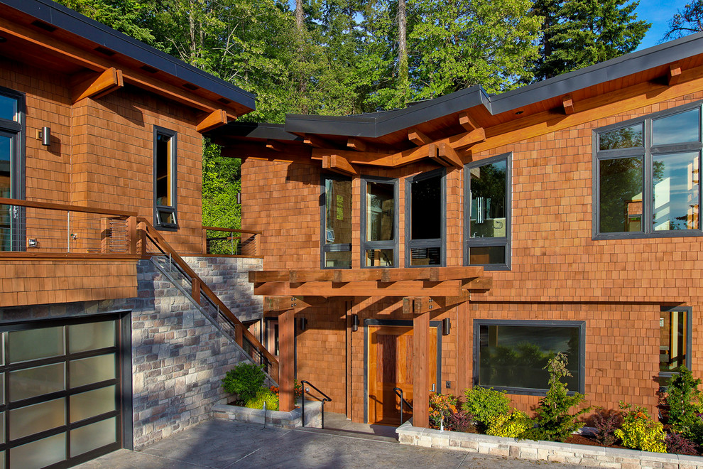 Imagen de fachada marrón actual grande de dos plantas con revestimiento de madera y tejado plano
