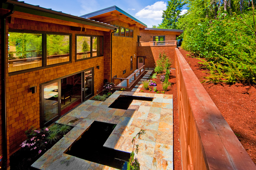 Modelo de fachada marrón contemporánea pequeña de dos plantas con revestimiento de madera y tejado plano