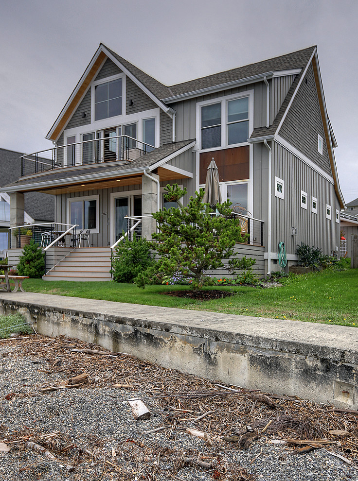 Diseño de fachada de casa gris y gris costera de tamaño medio de dos plantas con revestimientos combinados, tejado a dos aguas, tejado de teja de madera y panel y listón