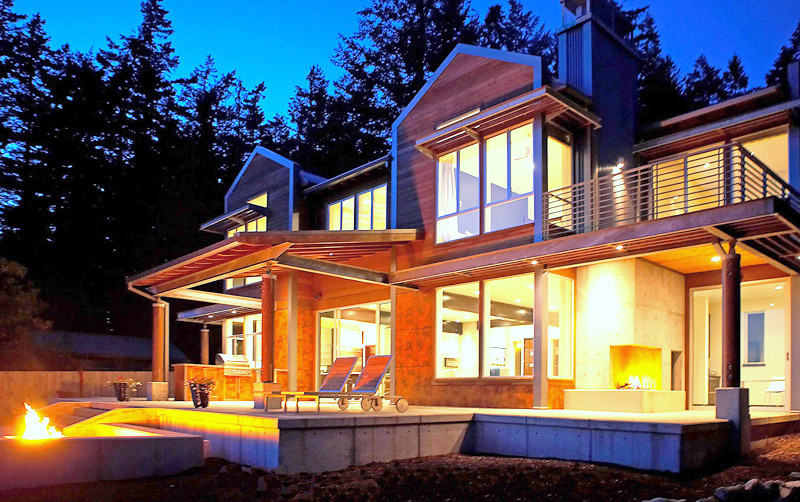 Идея дизайна: двухэтажный, коричневый частный загородный дом среднего размера в стиле модернизм с комбинированной облицовкой, двускатной крышей и металлической крышей