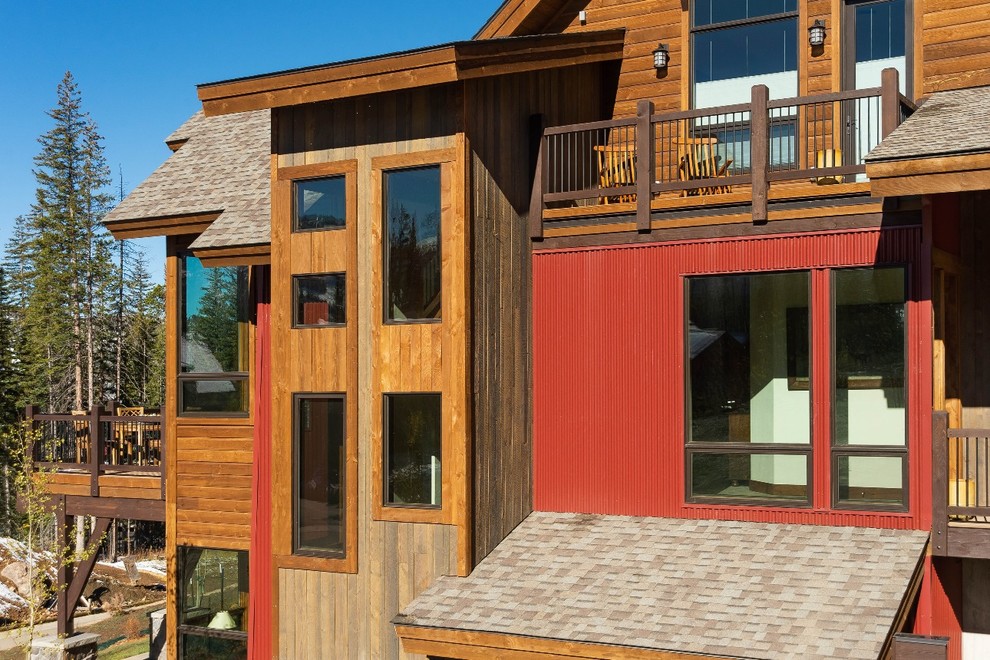 Ejemplo de fachada de casa bifamiliar marrón rural de tamaño medio de dos plantas con revestimientos combinados y tejado de teja de madera