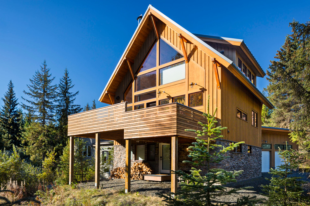 Exemple d'une façade de maison marron montagne en bois de taille moyenne et à deux étages et plus avec un toit à deux pans et un toit en métal.