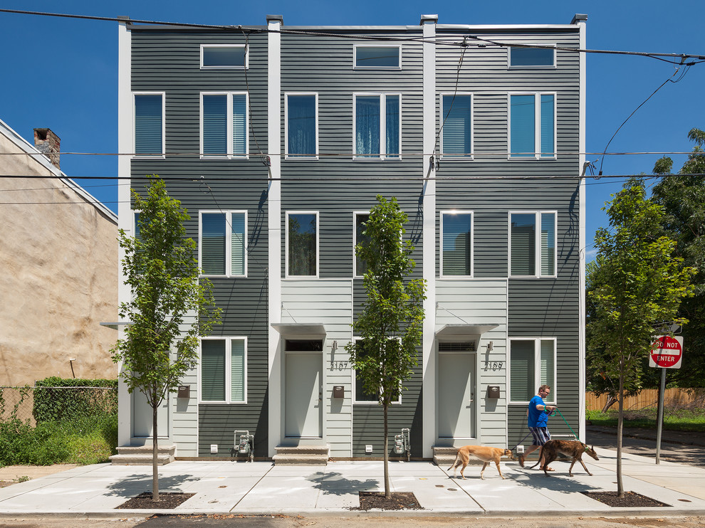 Ejemplo de fachada gris minimalista pequeña de tres plantas con revestimiento de aglomerado de cemento