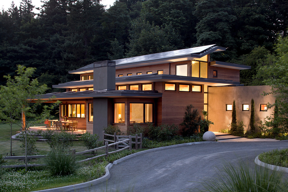 Стильный дизайн: большой, трехэтажный, деревянный, коричневый дом в современном стиле с плоской крышей - последний тренд