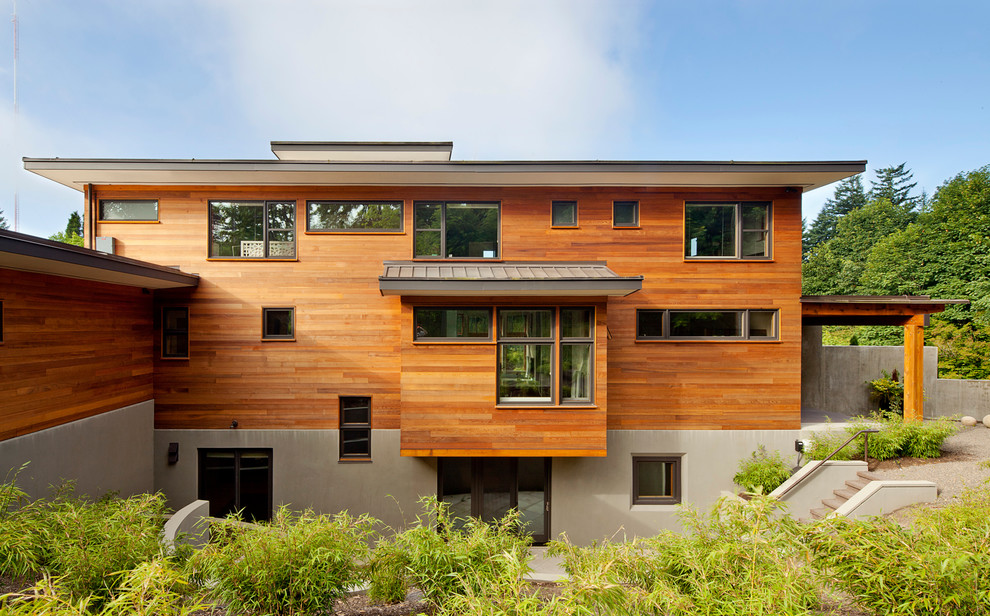 Inspiration for a large contemporary brown three-story wood flat roof remodel in Portland