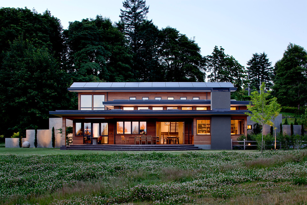 Imagen de fachada marrón contemporánea grande de tres plantas con revestimiento de madera y tejado plano