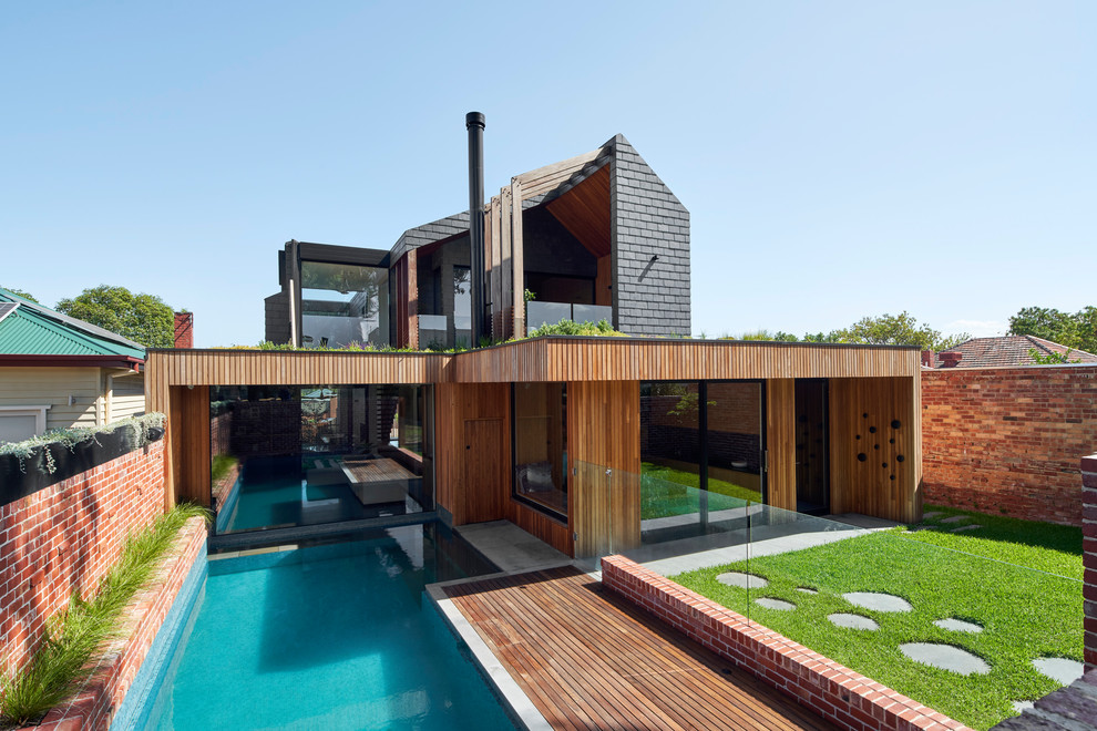 Foto della villa nera contemporanea con rivestimento in legno, tetto a capanna e copertura a scandole