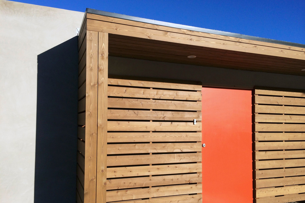 Ejemplo de fachada de casa gris de tamaño medio de una planta con revestimiento de madera y tejado plano