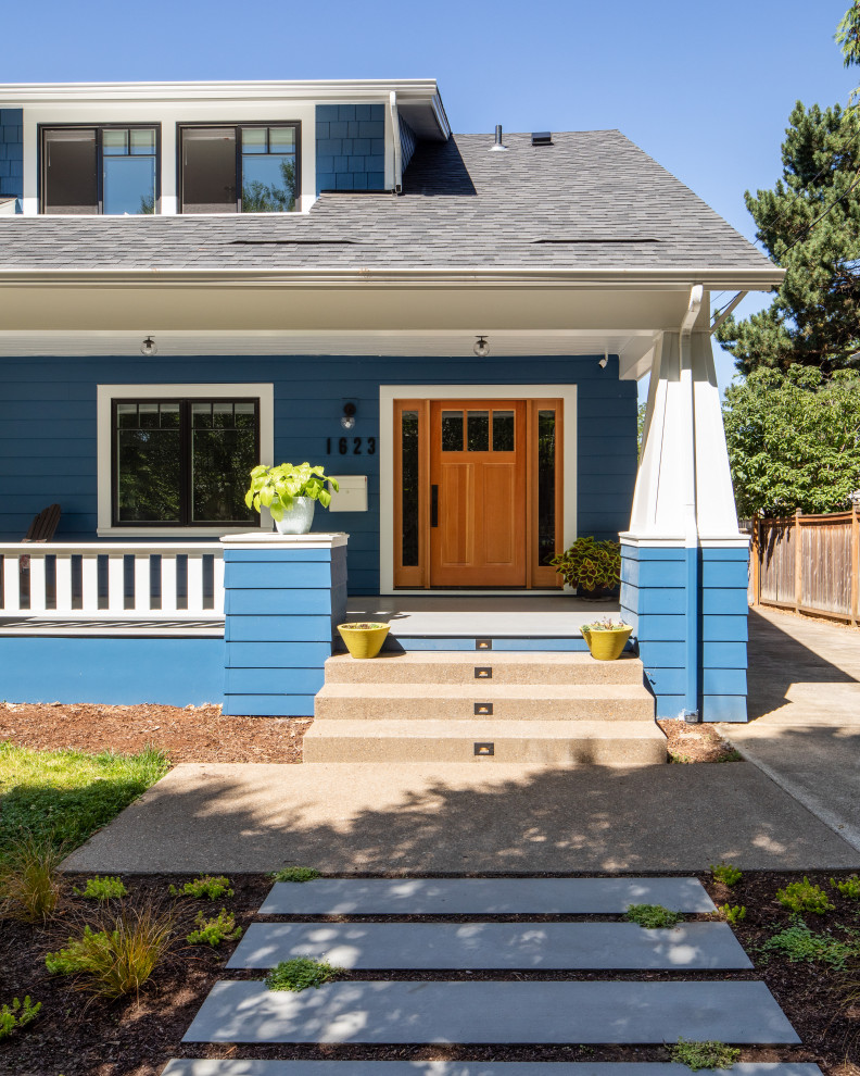 Aménagement d'une façade de maison bleue craftsman de taille moyenne et à deux étages et plus avec un revêtement en vinyle, un toit à deux pans et un toit en shingle.