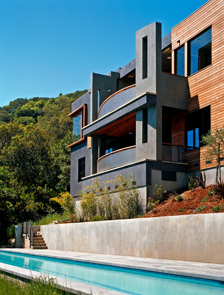 Immagine della facciata di una casa contemporanea a tre piani con rivestimenti misti e tetto piano