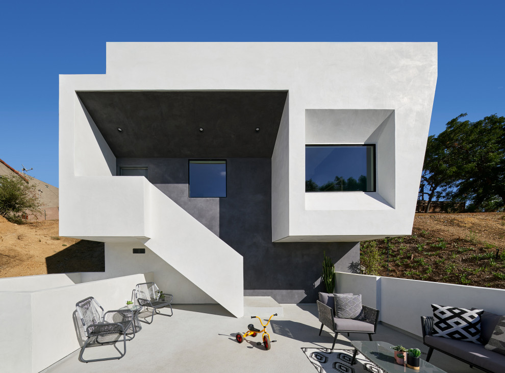 Diseño de fachada de casa blanca contemporánea de tamaño medio de dos plantas con revestimiento de estuco y tejado plano