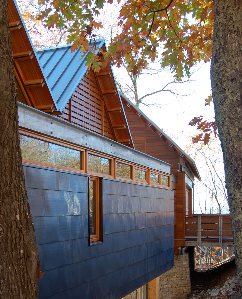 Cette photo montre une façade de maison marron et métallique chic de taille moyenne et à deux étages et plus avec un toit à deux pans et un toit en métal.