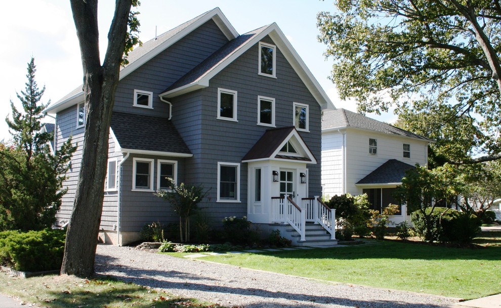 Ejemplo de fachada de casa gris de estilo de casa de campo de tamaño medio de dos plantas con revestimiento de vinilo, tejado a dos aguas y tejado de metal