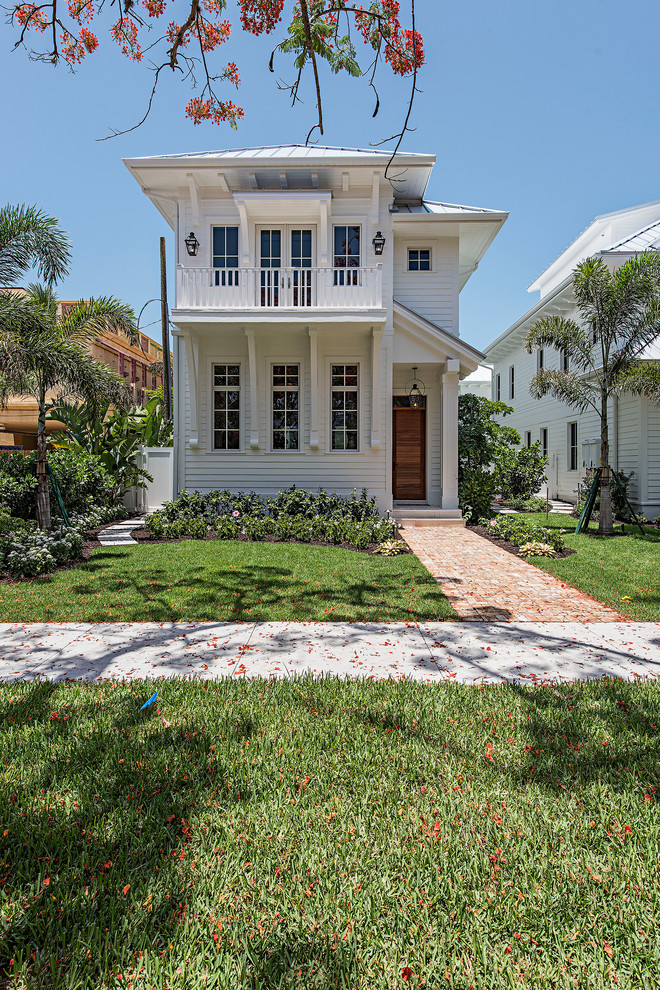 Zweistöckiges Maritimes Einfamilienhaus mit weißer Fassadenfarbe, Walmdach und Blechdach in Miami